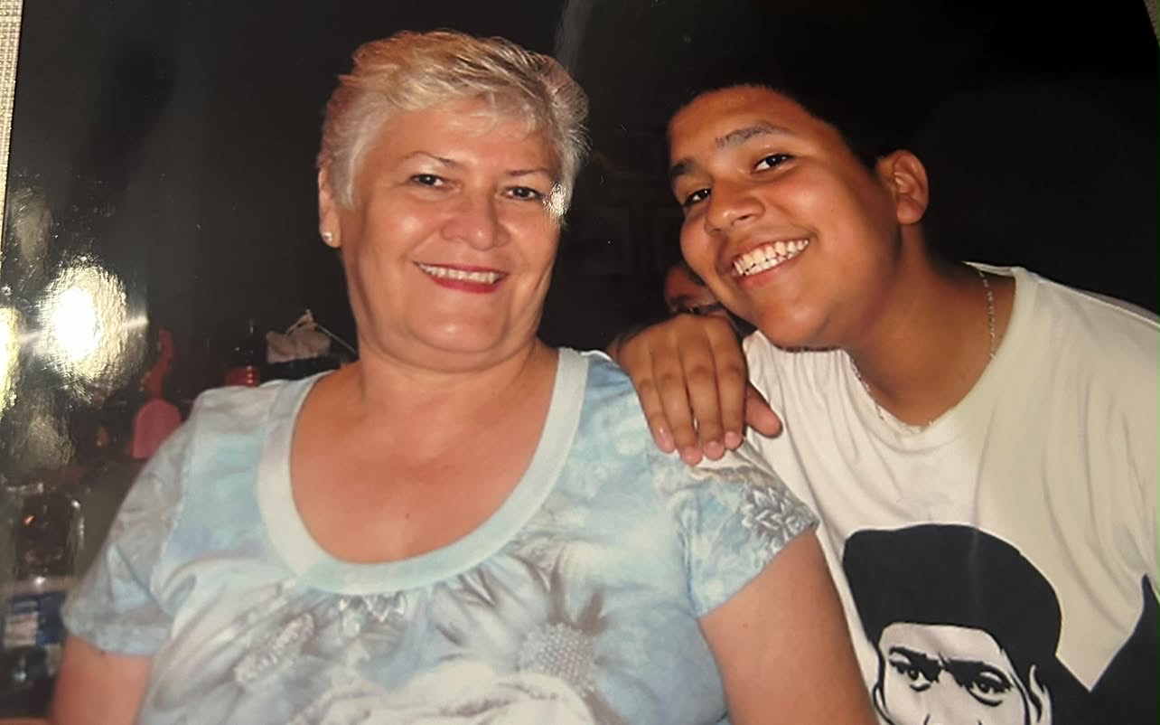 An older woman and a young man smiling together