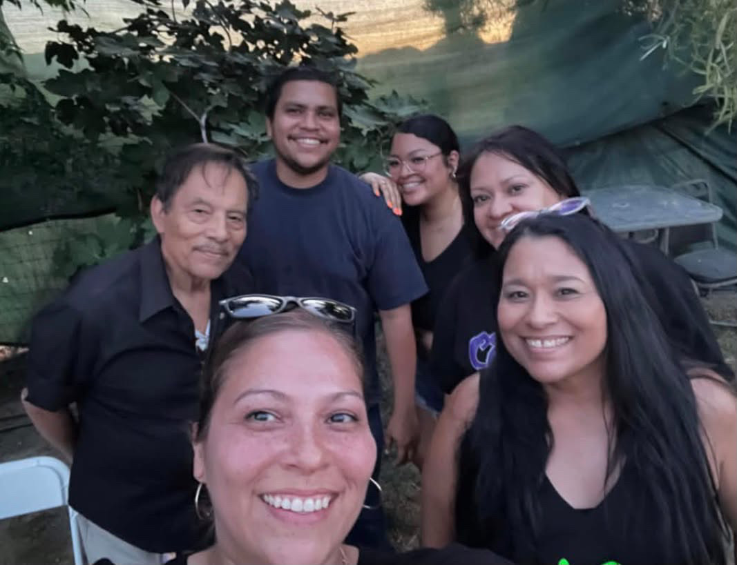 Six family members close together in an outdoor group selfie