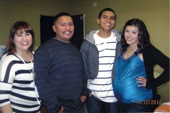 Mando as a teenager in a gray hooded jacket standing with family