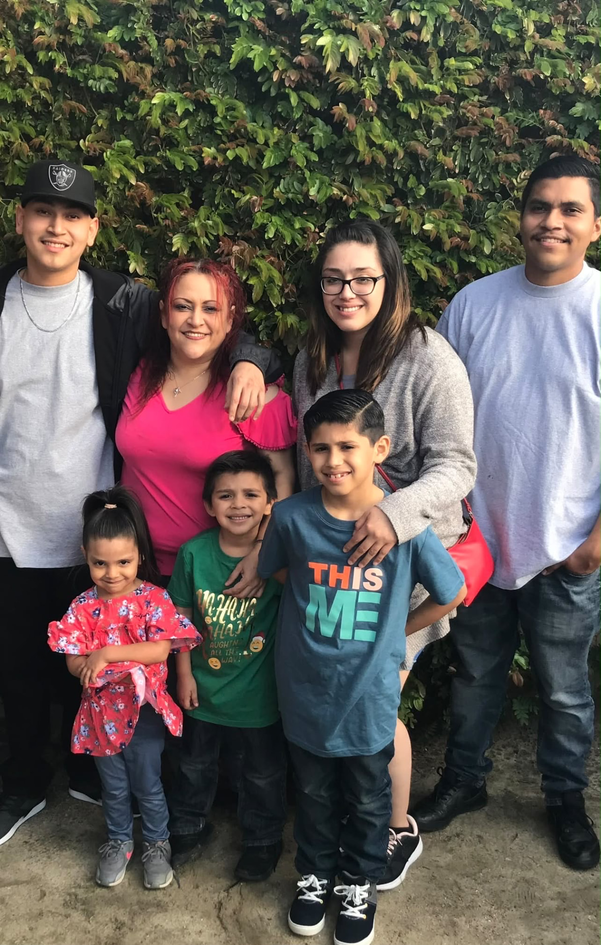A family group portrait of seven people standing together outdoors